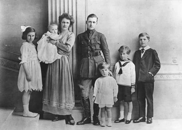 Nancy standing next to her husband, who&#x27;s wearing a uniform, and their five children looking into the camera.